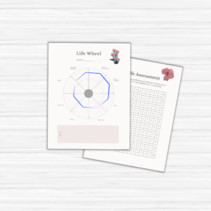 A pair of pages rests on a white wooden surface: one showcasing a life wheel chart and the other featuring an assessment grid, both embellished with floral designs, ideal for your Vision Board Workbook.